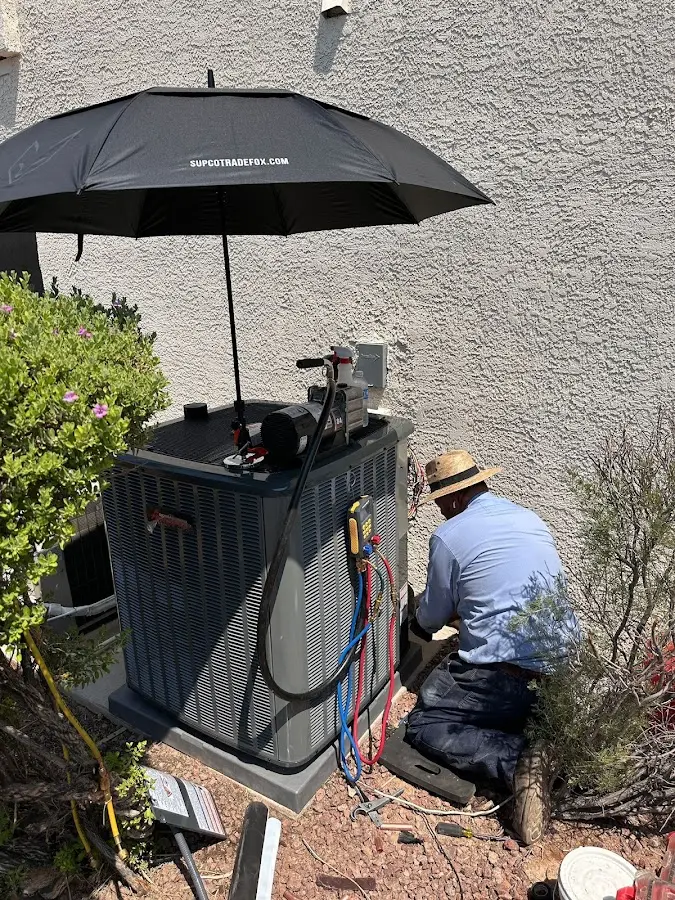 HVAC technician performing outdoor AC maintenance in Dodge City