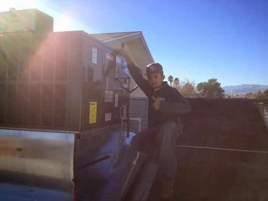 HVAC technician performing Heat Pump Repair on a rooftop unit in Dodge City